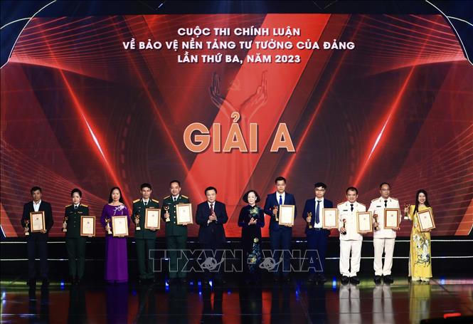 Đồng chí Trương Thị Mai, Ủy viên Bộ Chính trị, Thường trực Ban Bí thư, Trưởng Ban Tổ chức Trung ương và đồng chí Nguyễn Xuân Thắng, Ủy viên Bộ Chính trị, Giám đốc Học viện Chính trị Quốc gia Hồ Chí Minh, Chủ tịch Hội đồng lý luận Trung ương trao giải A cho các tác giả, nhóm tác giả (ảnh Thông tấn xã Việt Nam). vna_potal_le_trao_giai_cuoc_thi_chinh_luan_ve_bao_ve_nen_tang_tu_tuong_cua_dang_lan_thu_ba_nam_2023_stand (1).jpeg