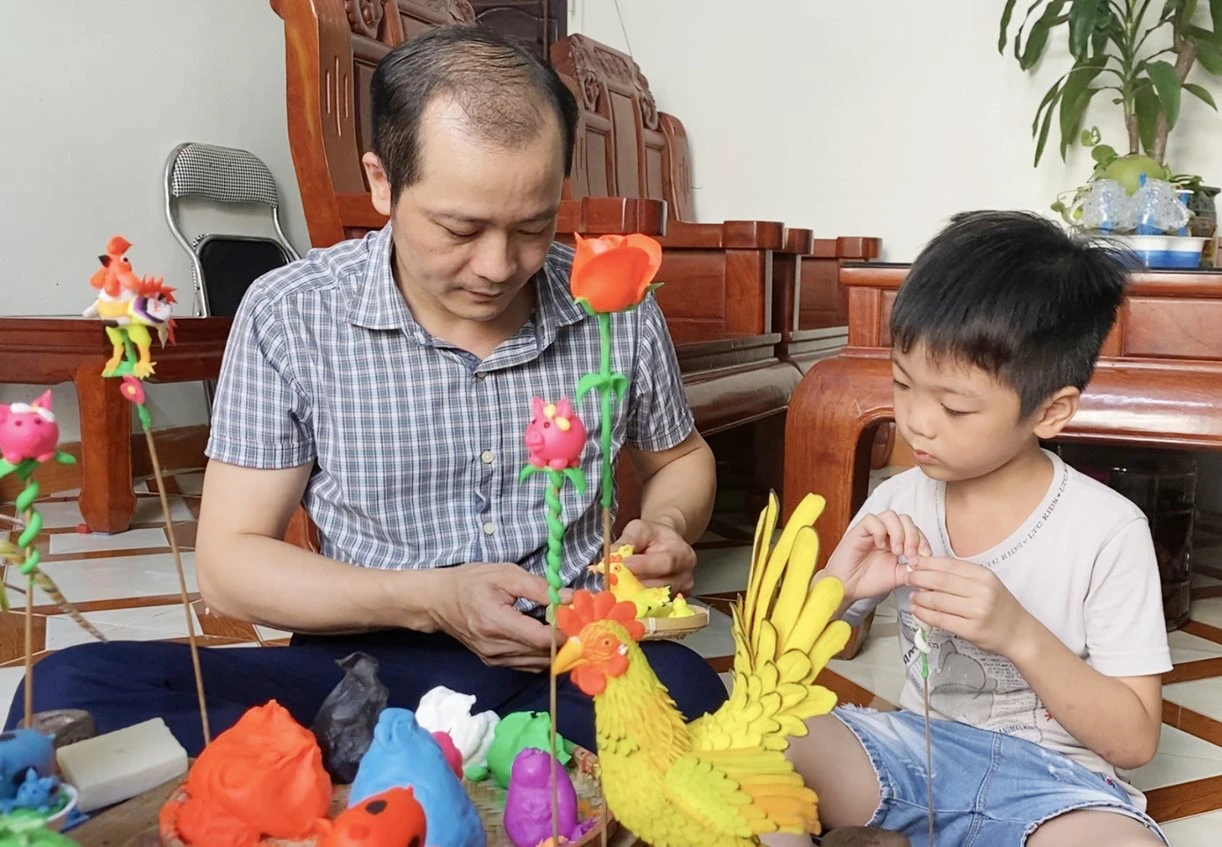 Nghệ nhân Ưu tú Nguyễn Văn Thành hướng dẫn con trai các bước nặn tò he.