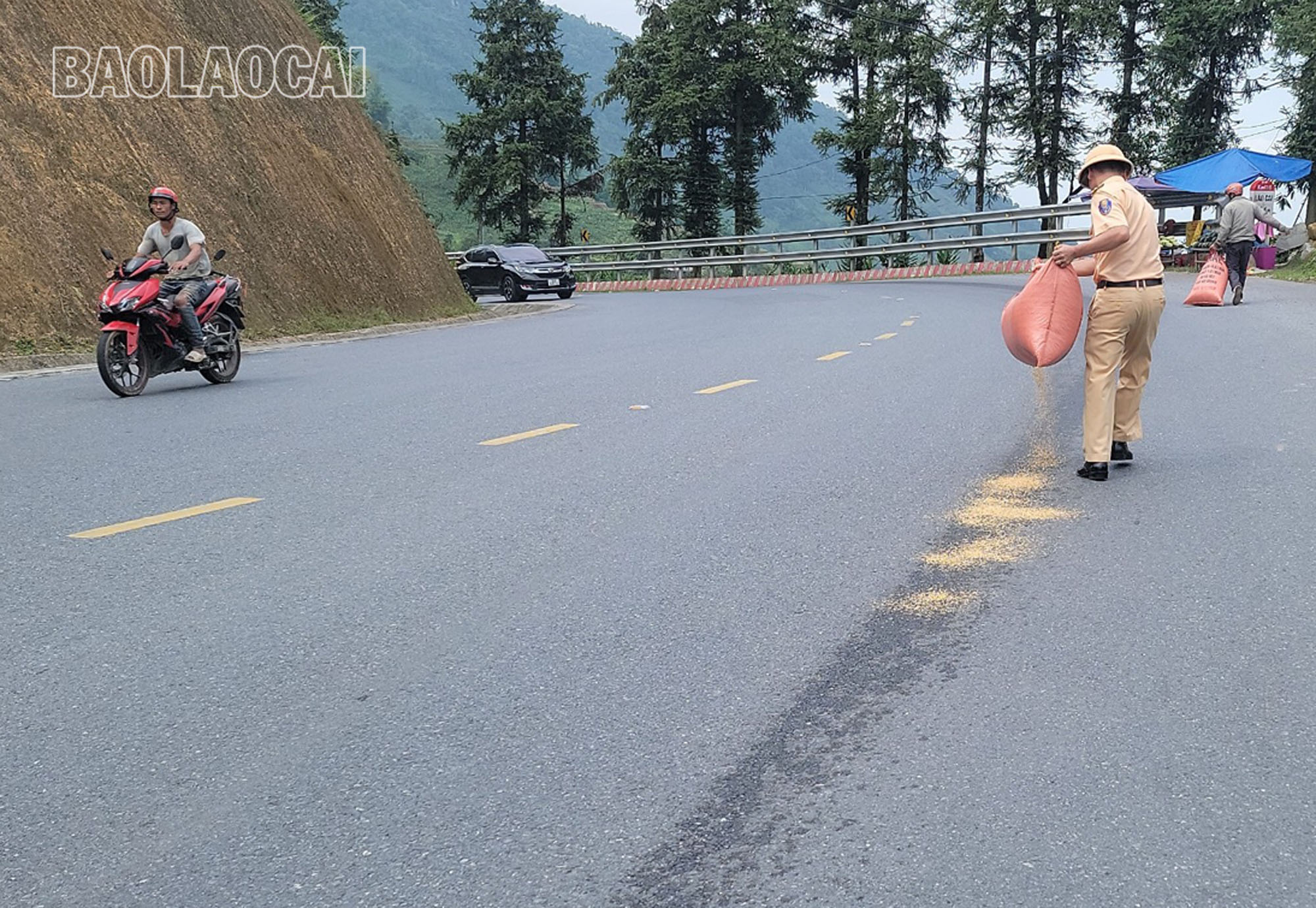 Cán bộ, chiến sĩ Tổ công tác thuộc Đội 6, Phòng Cảnh sát giao thông, Công an tỉnh rải trấu lên vết dầu loang tránh trơn trượt cho các phương tiện giao thông. A3.jpg