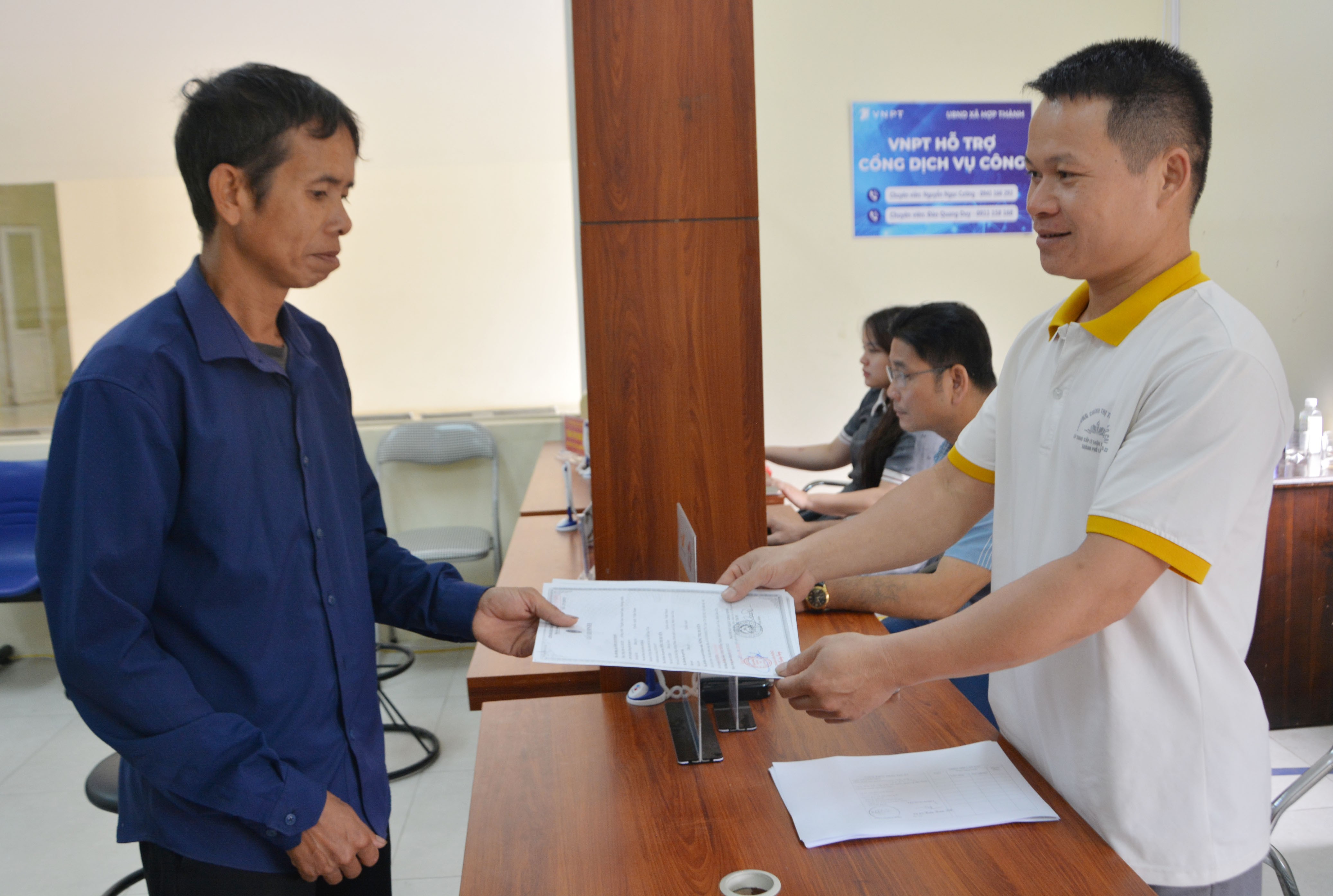Cán bộ Trung tâm Phục vụ hành chính công xã Hợp Thành trả kết quả giải quyết cho người dân. dsc-8360.jpg