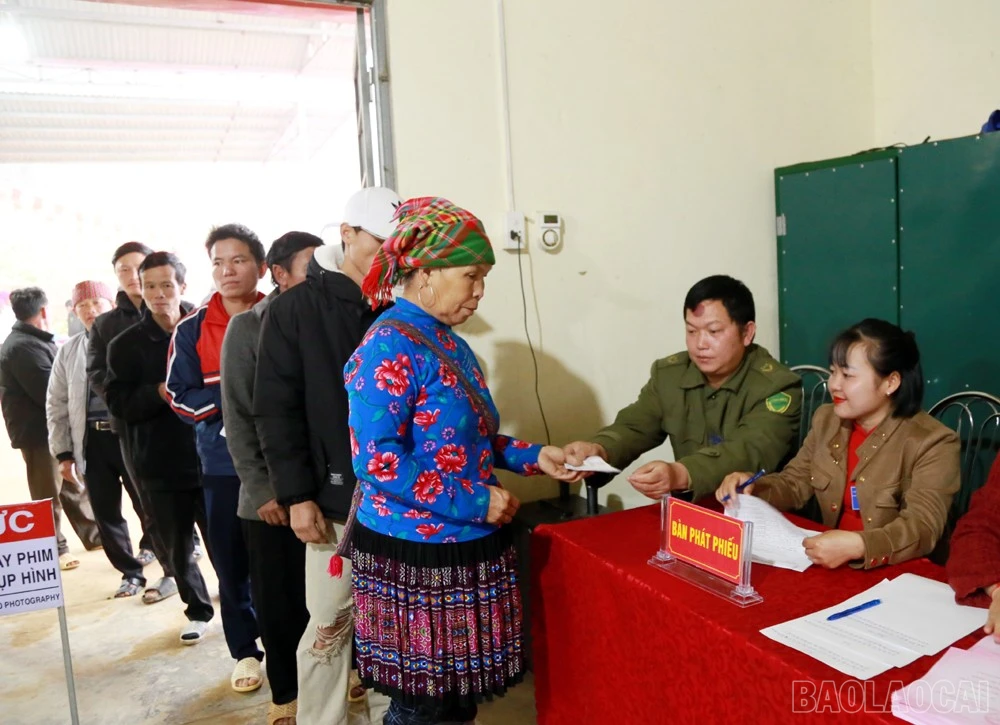 Cử tri nhận phiếu bầu cử tại khu vực bỏ phiếu số 11, xã Dền Sáng.