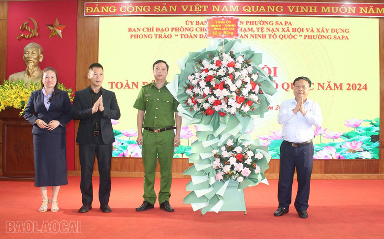 Đồng chí Nguyễn Trọng Hài, Phó Chủ tịch UBND tỉnh tặng hoa của Tỉnh ủy, HĐND, UBND tỉnh cho phường Sa Pa.