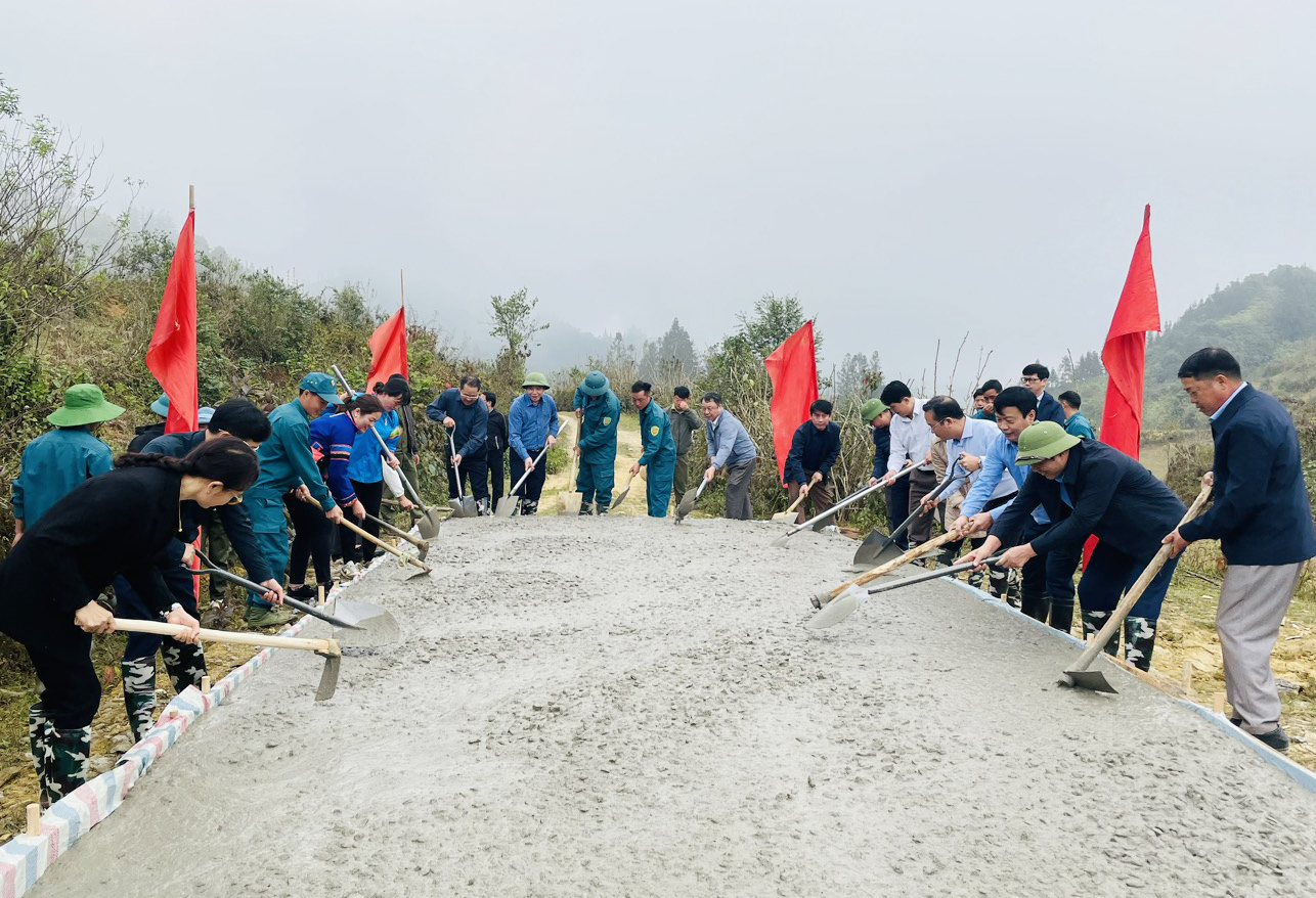 Các đại biểu và người dân tham gia đổ bê tông đường giao thông nông thôn. BHH2.jpg