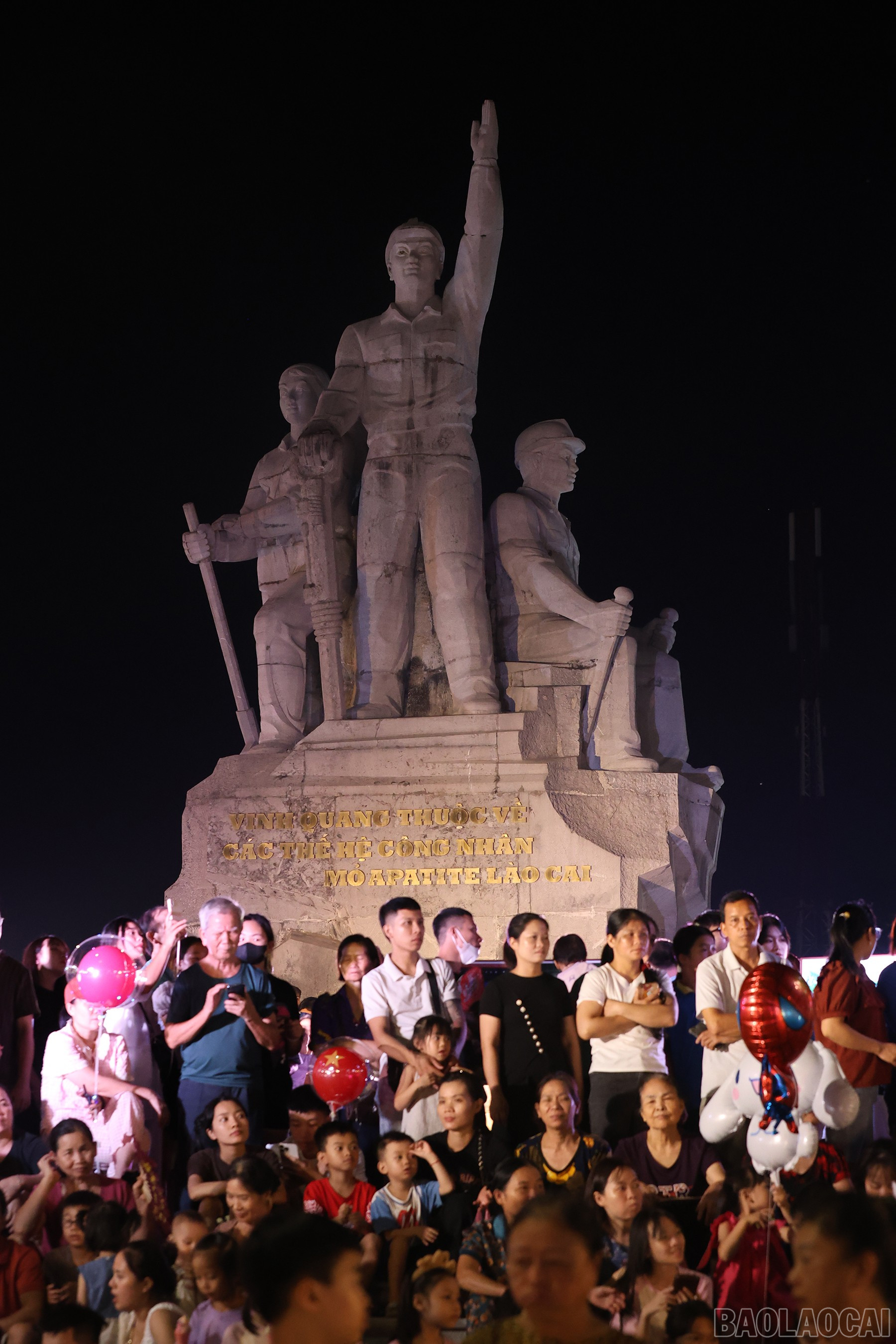 Người dân đứng bên Tượng đài công nhân vùng mỏ theo dõi chương trình nghệ thuật. baolaocai-br_img-6371.jpg