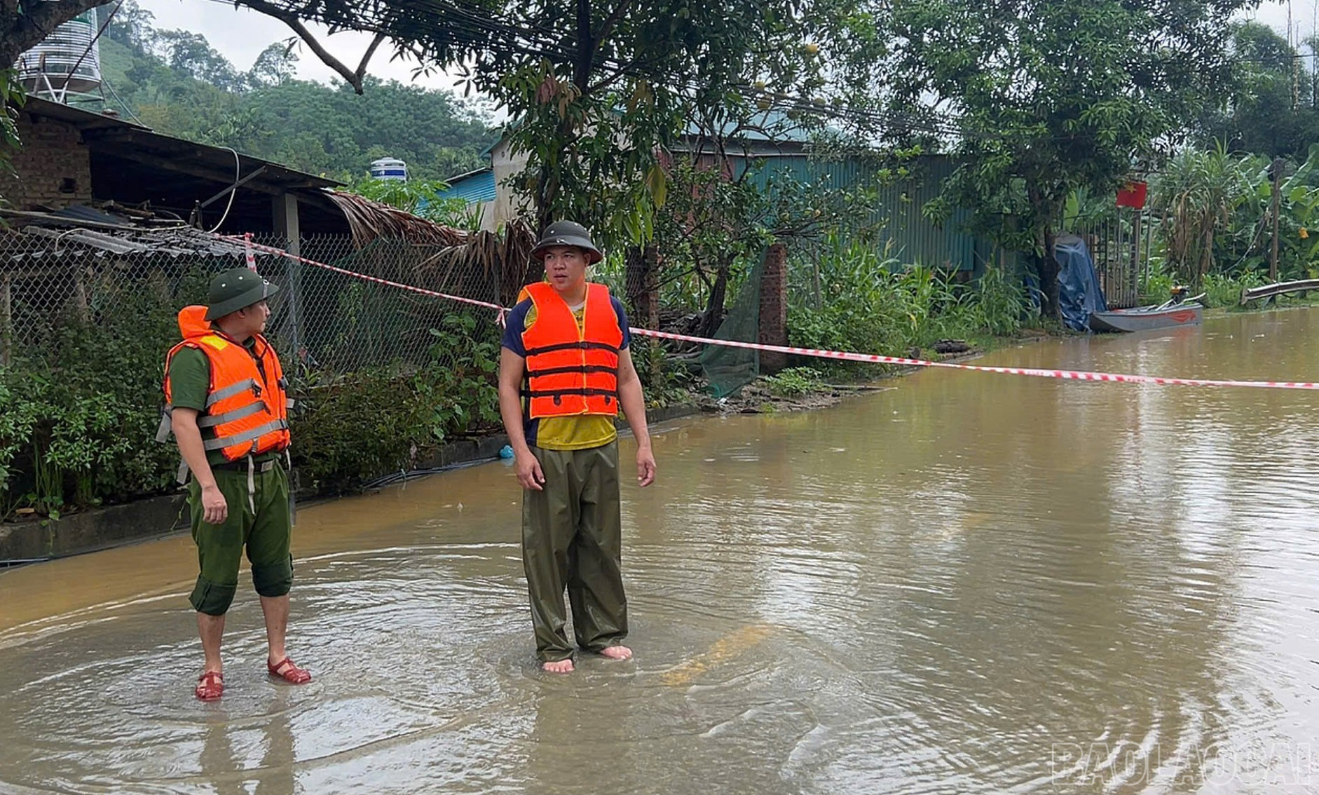 Công an xã căng dây trên các tuyến đường ngập sâu cảnh báo người dân không đi qua khu vực nguy hiểm.