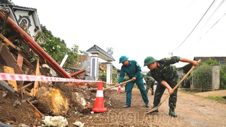 Cán bộ, chiến sĩ Bộ CHQS tỉnh hỗ trợ các hộ dân khắc phục hậu quả sạt lở đất tại xã Xuân Ái