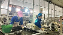 Workers of Hoang Lien S&#111;n Technical Ceramics jo&#105;nt Stock Company during their shift.