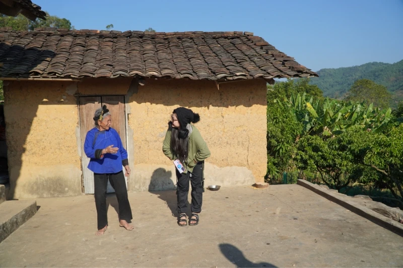 Du khách trò chuyện với cụ bà Vi Thị Thêm.