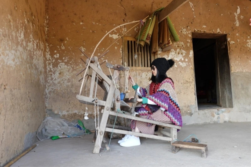 Du khách trải nghiệm dệt khăn chàm.