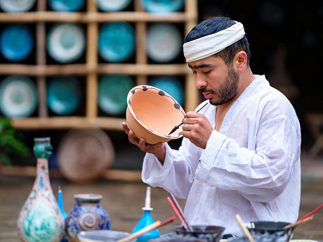 Nghệ nhân gốm trang trí hoa văn trên sản phẩm truyền thống.
