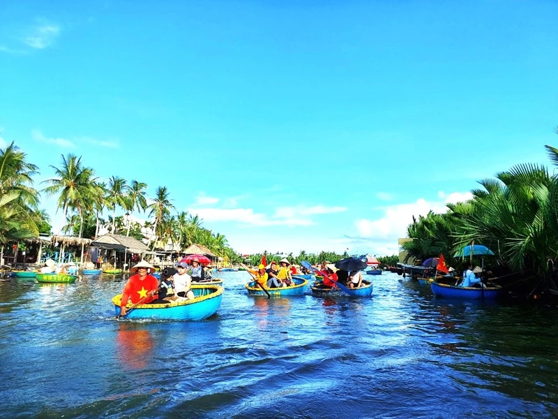 Du khách đi giữa dòng Thu Bồn, hai bên là những vạt dừa xanh ngút ngàn.