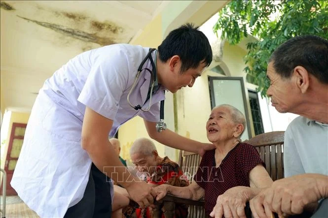 Những cử chỉ chăm sóc tận tình mang đến sự ấm áp cho người có công và đối tượng bảo trợ xã hội. Ảnh minh họa: Hữu Quyết/TTXVN