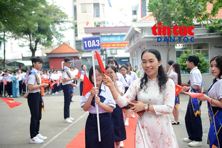 Cô giáo đồng hành cùng học sinh tiến vào lễ khai giảng, mở đầu một năm học mới với nhiều niềm vui và kỳ vọng.