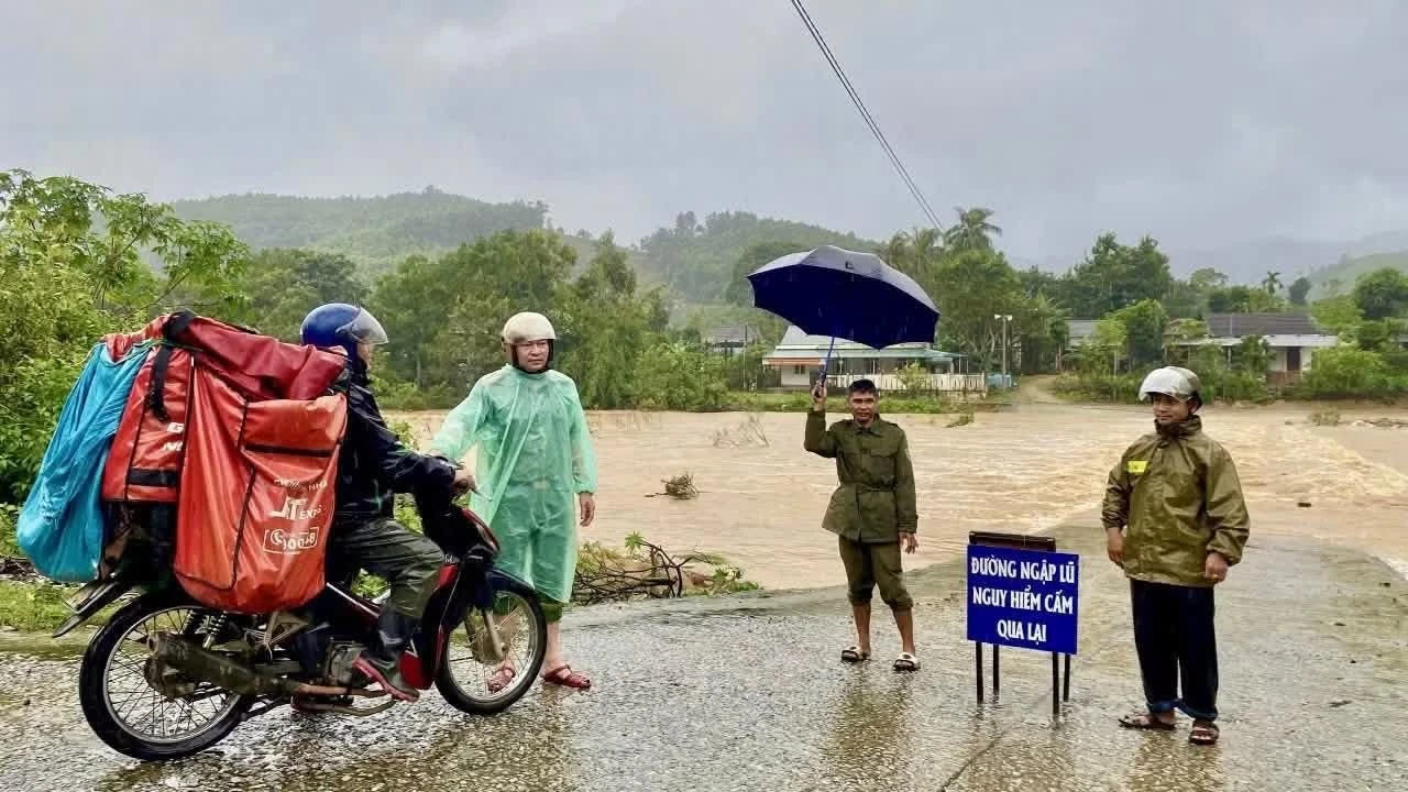 Lực lượng chức năng cảnh báo tuyến đường ngập sâu tại Quảng Trị do mưa lớn từ áp thấp nhiệt đới.