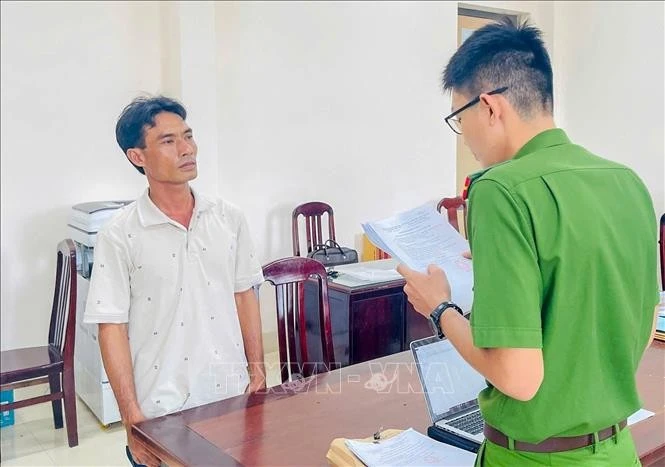 Cơ quan Cảnh sát điều tra Công an thành phố Cần Thơ tống đạt các quyết định với đối tượng Hứa Hoàng Khởi. Ảnh: TTXVN phát
