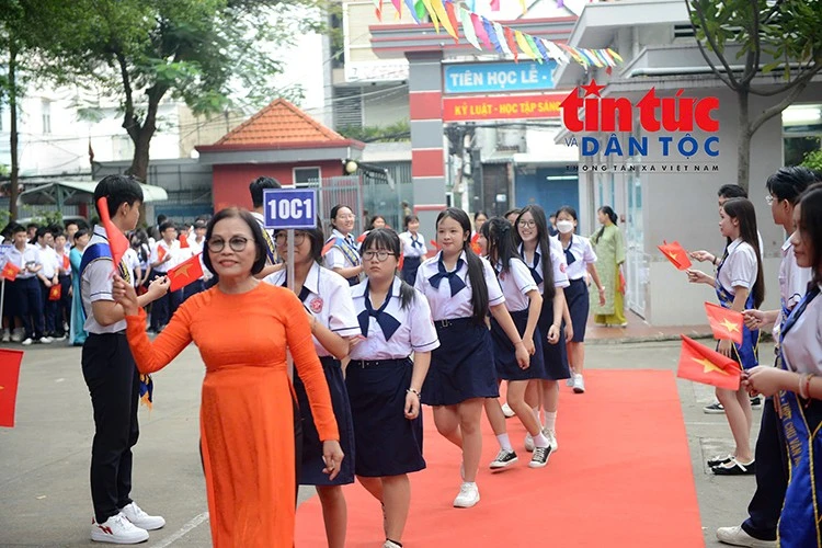 Giáo viên dẫn học sinh vào khu vực lễ khai giảng trong sự chào đón nồng nhiệt của thầy cô và các bạn.