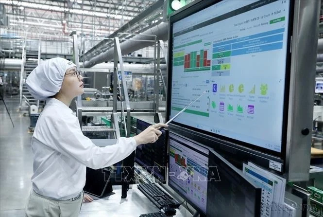 Công nhân Nhà máy Bông Sen (Tập đoàn Nestlé Việt Nam) đang vận hành dây chuyền sản xuất bằng bảng điều khiển tự động. Ảnh: Mạnh Khánh/TTXVN