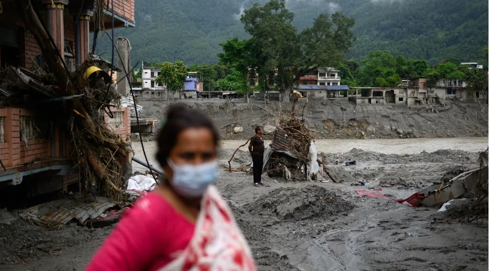 Người dân Devigart, Nepal nhìn những ngôi nhà của họ bị phủ đầy bùn. (Ảnh: AFP/Manan VATSYAYANA)