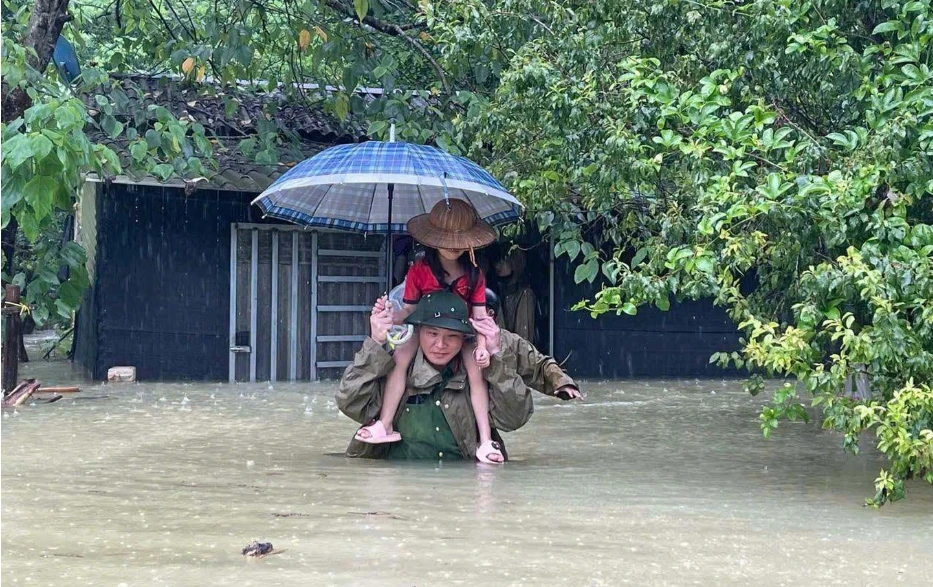 Lực lượng chức năng hỗ trợ người dân ra khỏi vùng ngập lụt (Ảnh: Công an Cao Bằng).