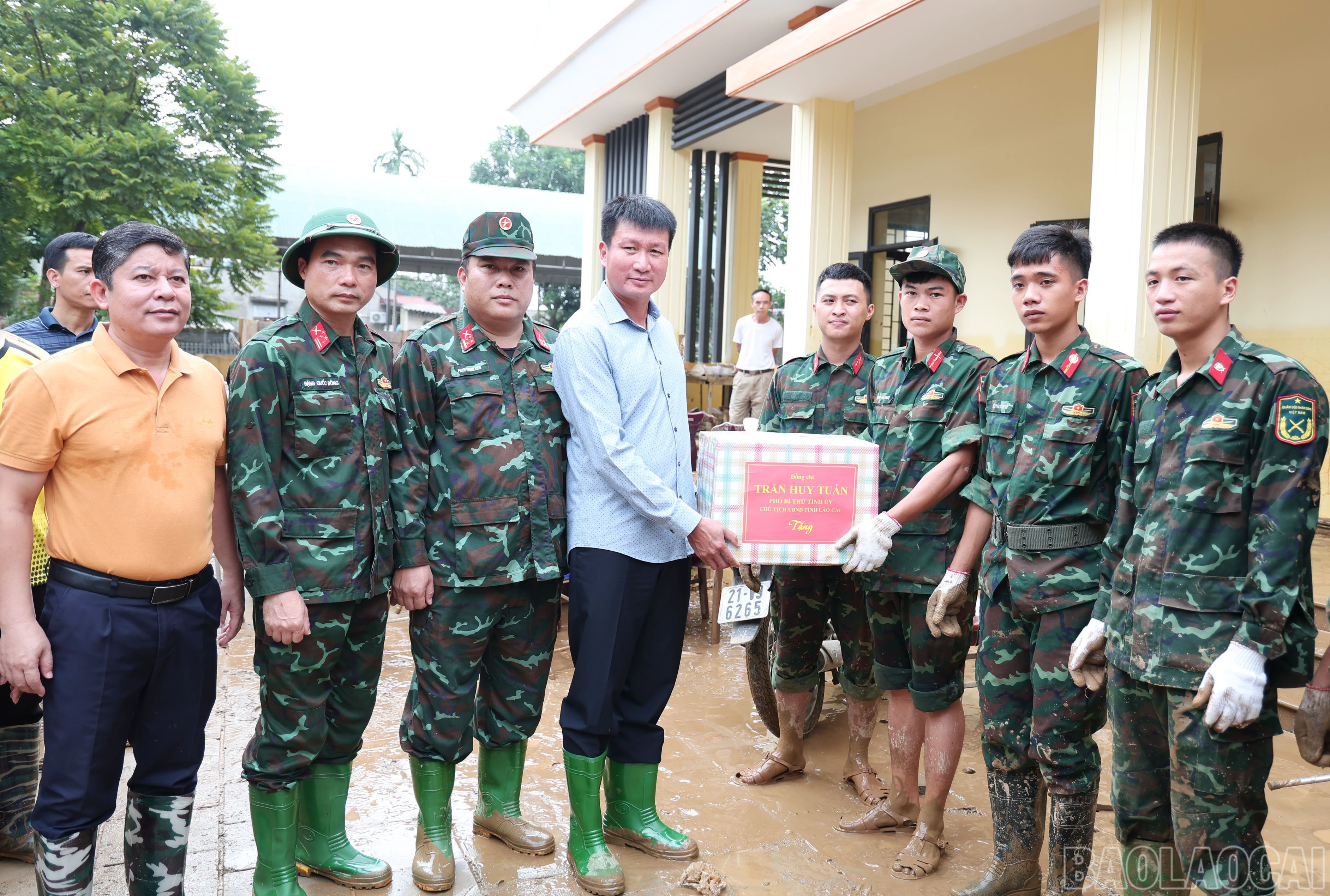 Đồng chí Trần Huy Tuấn – Phó Bí thư Tỉnh ủy, Chủ tịch UBND tỉnh tặng quà động viên bộ đội giúp dọn bùn đất tại Nhà văn hóa tổ dân phố số 5. baolaocai-br_img-4197.jpg