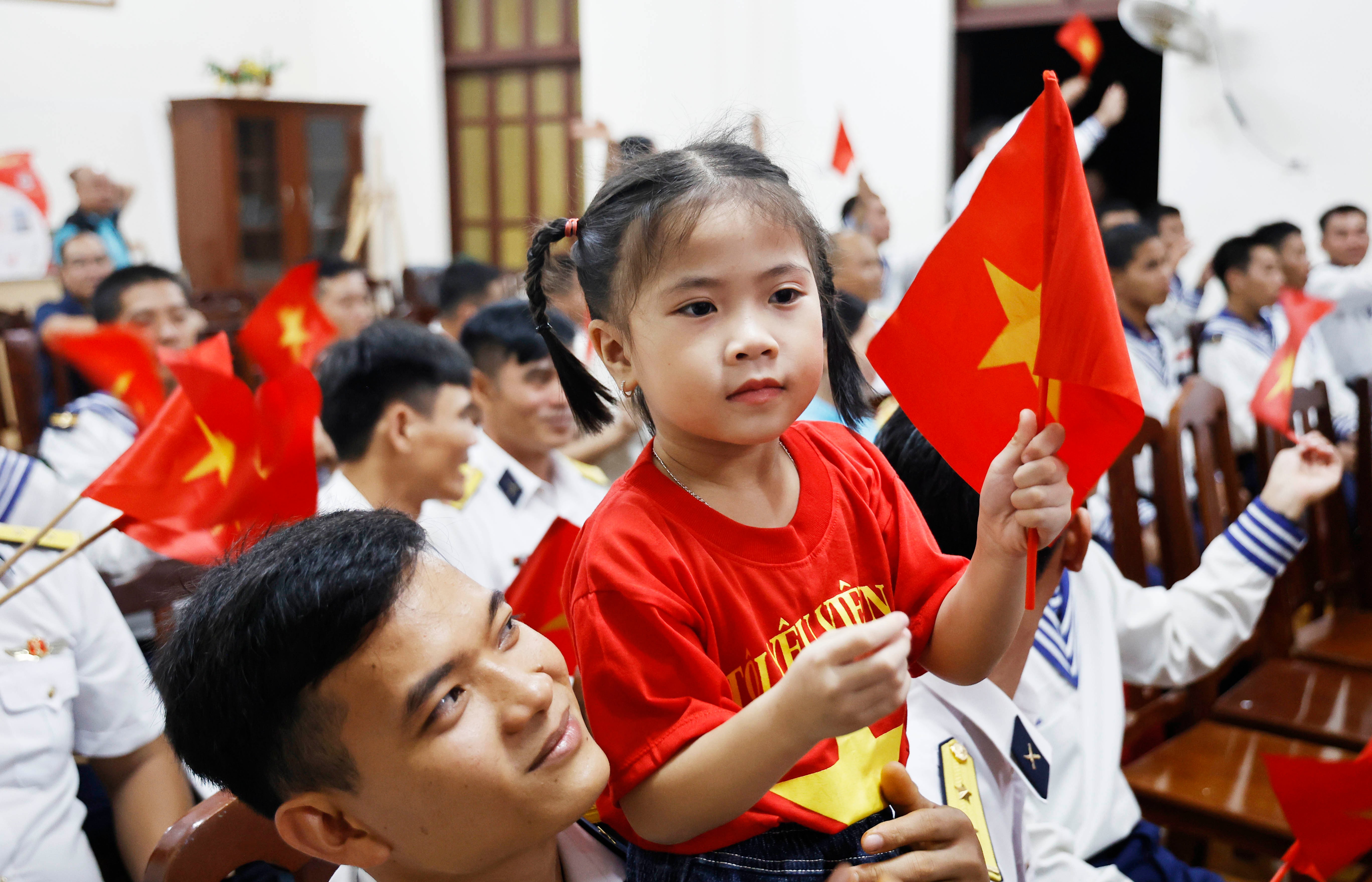 Một em bé nép mình bên chú bộ đội Hải quân trên đảo Đá Tây A (ảnh trên), hay em nhỏ đảo Trường Sa xinh xắn trong chiếc áo cờ đỏ sao vàng (ảnh dưới), tất cả đã tạo nên những nét đẹp tình quân dân bình dị mà thiêng liêng. 8771.jpg