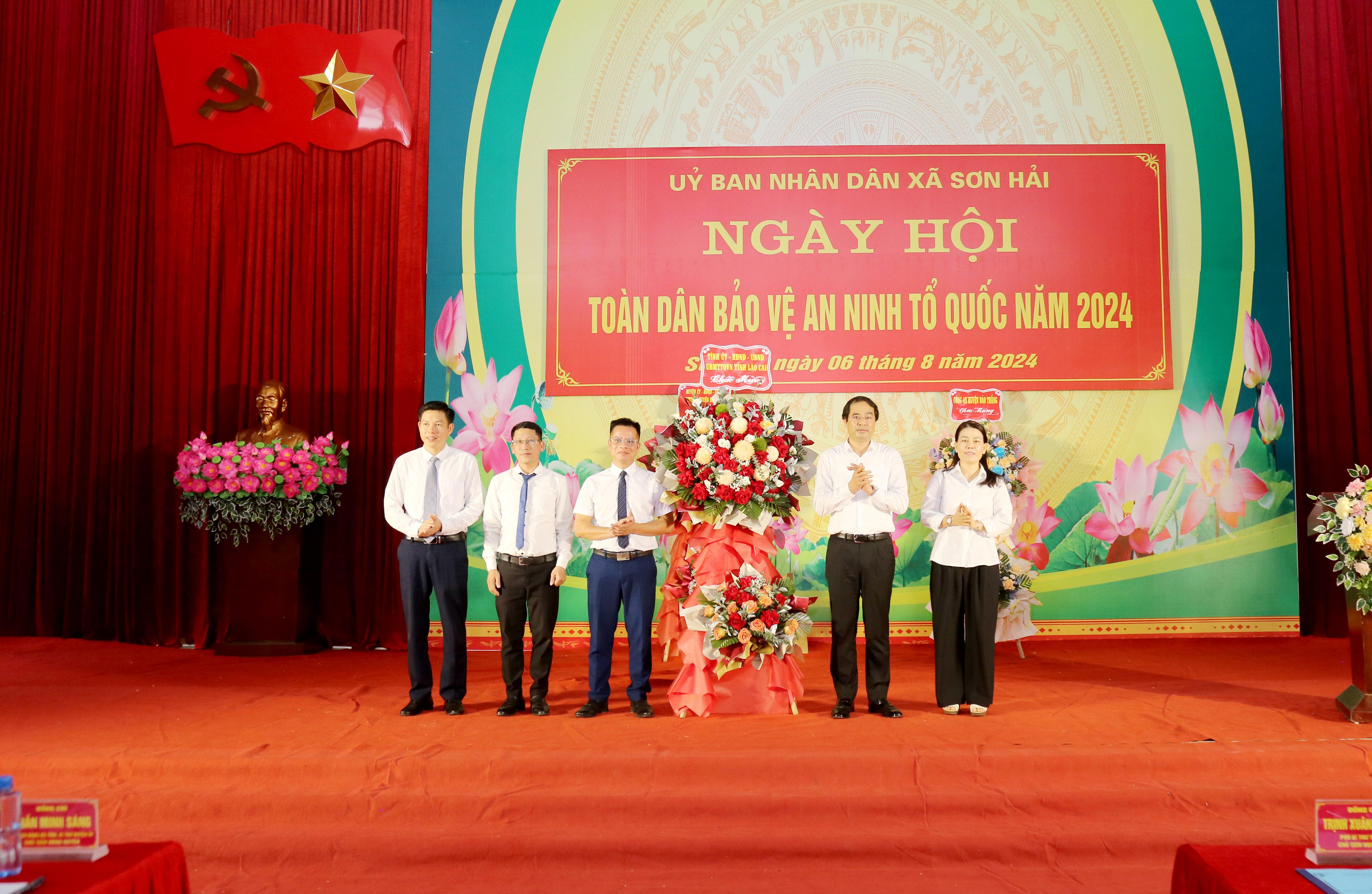 Đồng chí Chủ tịch UBND tỉnh Trịnh Xuân Trường tặng hoa chúc mừng ngày hội tại xã Sơn Hải. IMG_1986.JPG