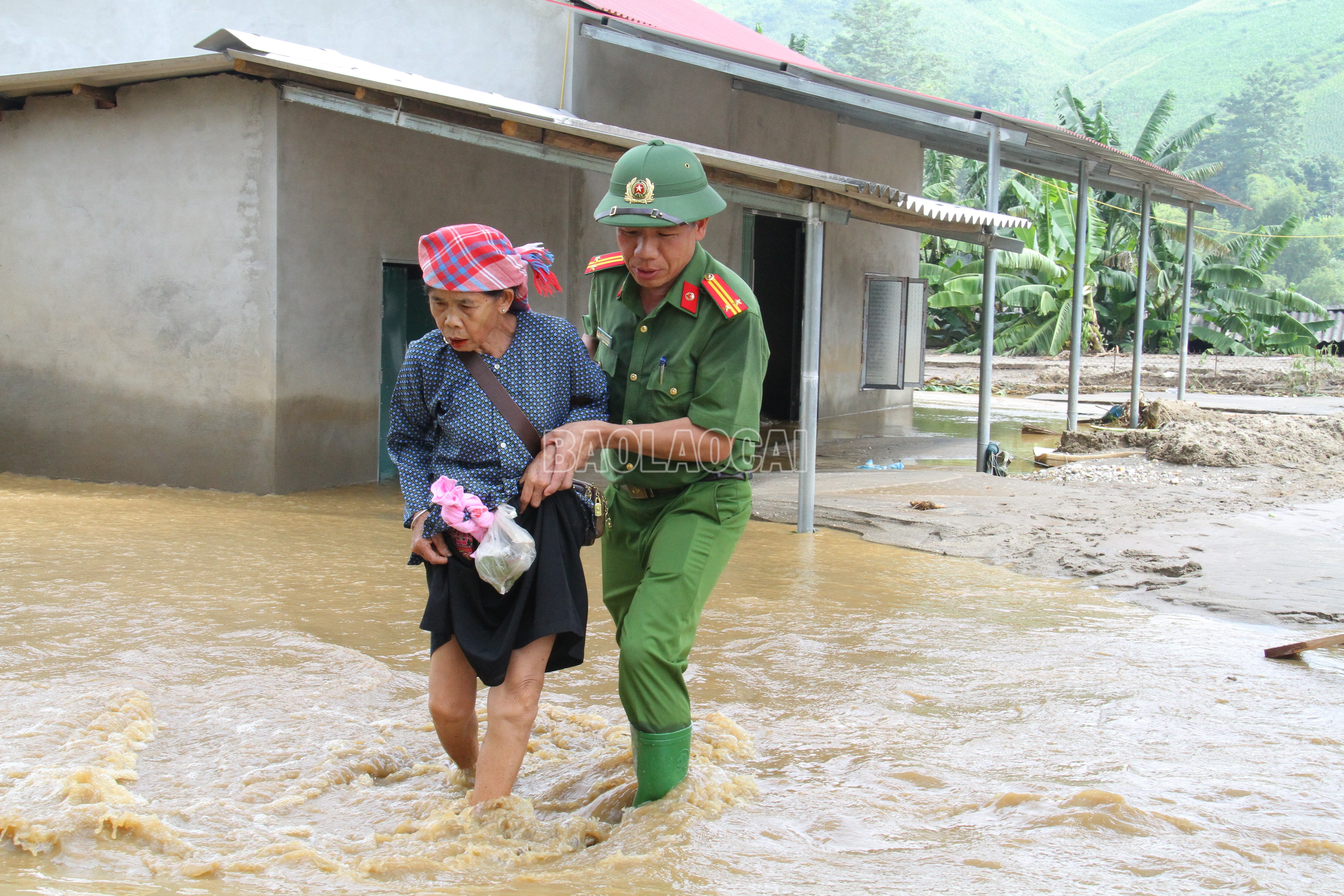 Công an xã Văn Bàn hỗ trợ người dân di chuyển tới nơi an toàn. Ảnh: Quỳnh Trang. image-2.jpg