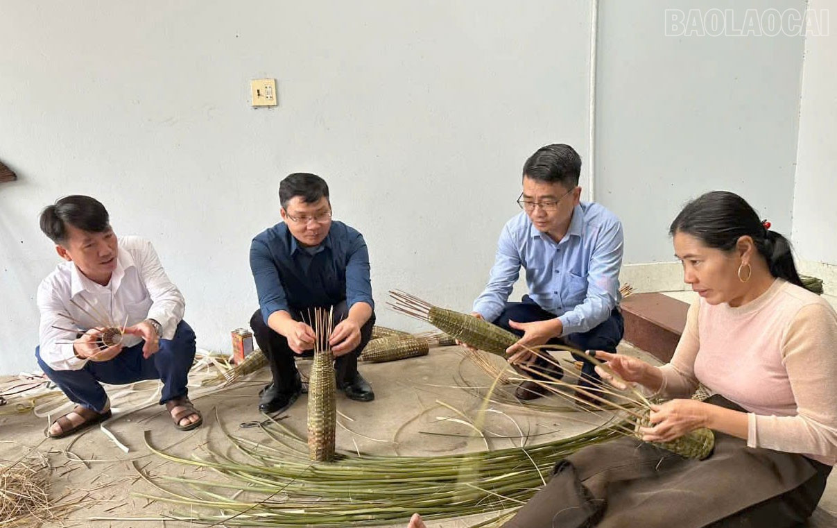 En. Vu Quoc Hieu - Pengerusi Jawatankuasa Rakyat Komune Yen Thanh (orang kedua, kanan) meninjau model kraf anyaman bakul udang di kampung Dong Tam 1. baolaocai-tr_3.jpg