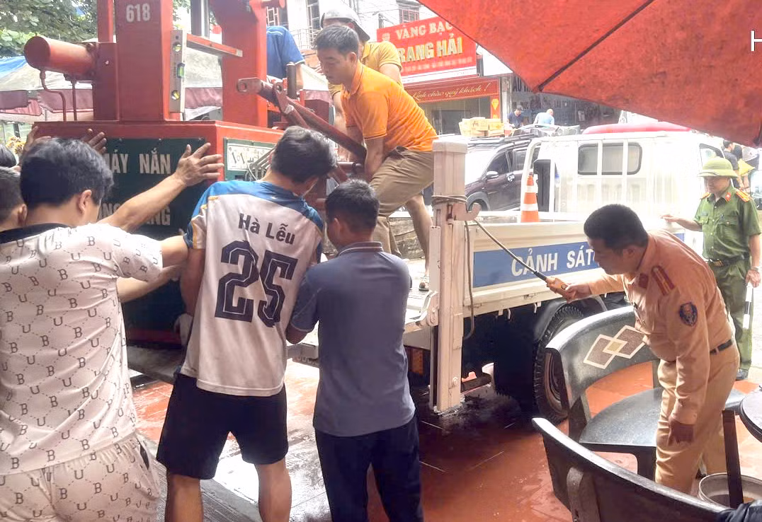 Không chỉ làm nhiệm vụ điều tiết, các chiến sĩ Cảnh sát giao thông trực tiếp giúp di dời tài sản cho các hộ dân gần khu vực nguy hiểm đến nơi an toàn