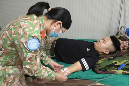 Nữ quân nhân thuộc Bệnh viện dã chiến cấp 1 - Đội Công binh số 4 chăm sóc y tế cho đồng nghiệp tại đơn vị.