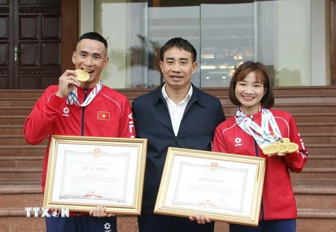 Vận động viên điền kinh Nguyễn Thị Oanh cùng huấn luyện viên.