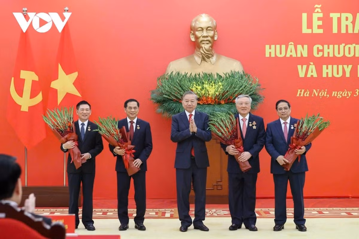 Tổng Bí thư Tô Lâm tặng hoa chúc mừng các đồng chí được nhận Huy hiệu Đảng.