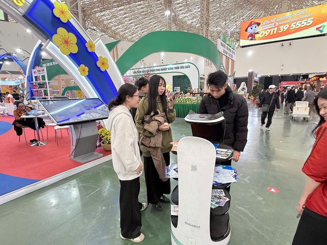 Khách tham quan thích thú với robot giới thiệu sản phẩm tại hội chợ.