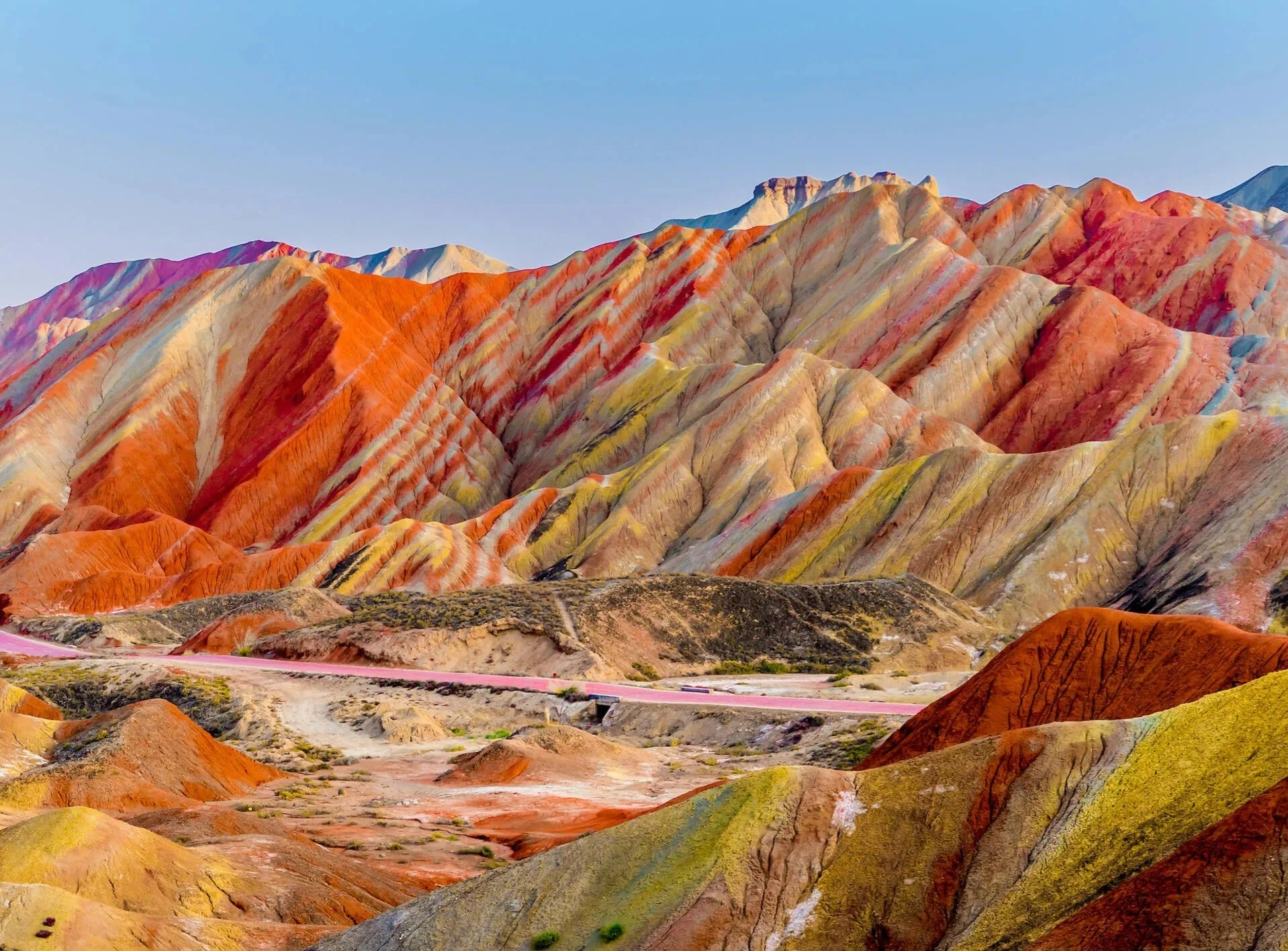 Nằm trong Công viên địa chất quốc gia Trương Dã, dãy núi Cầu Vồng là một trong nhiều kỳ quan thiên nhiên tuyệt vời nhất của Trung Quốc. Những vệt màu đỏ thẫm, vàng óng và xanh rêu tô điểm cho sườn đồi; một khối đất đa sắc màu tuyệt đẹp được hình thành qua hàng triệu năm bởi sự dịch chuyển của các mảng kiến tạo và thời tiết, khiến đá sa thạch đỏ và nhiều khoáng chất khác nhau trộn lẫn với nhau