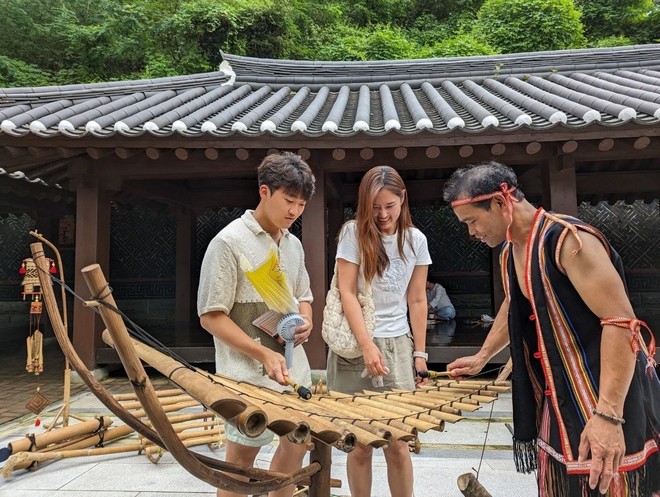 Du khách nước ngoài trải nghiệm di sản văn hóa của đồng bào vùng đất Tây Nguyên, Việt Nam.