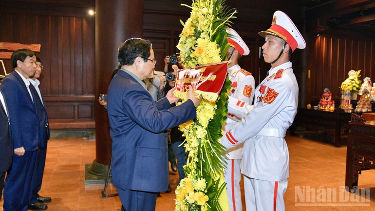 Thủ tướng Phạm Minh Chính chỉnh hoa trước khi thực hiện nghi lễ dâng hương, dâng hoa tưởng nhớ các Anh hùng liệt sĩ chiến trường Điện Biên Phủ.