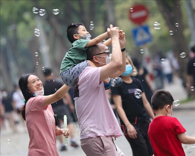 Một gia đình đang vui đùa với bong bóng trên phố đi bộ Hồ Gươm.