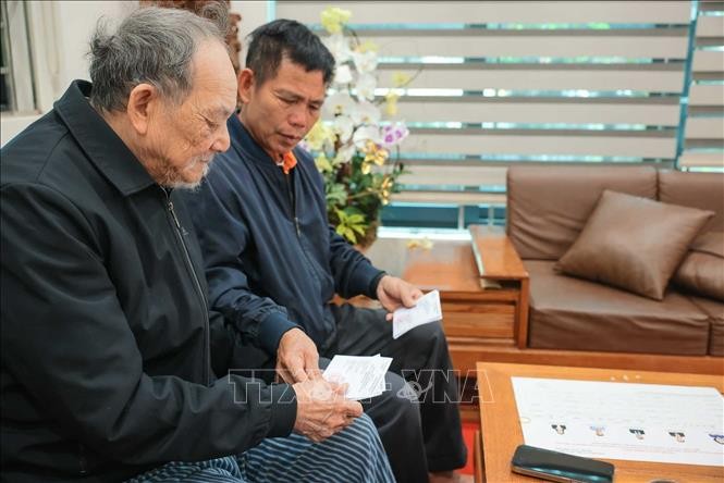 Nhân viên tổ bầu cử đưa thẻ cử tri đến hộ gia đình ông Nguyễn Trí Tuy, cụm dân cư số 3, thôn Hạ Mỗ, xã ô Diên (TP Hà Nội).