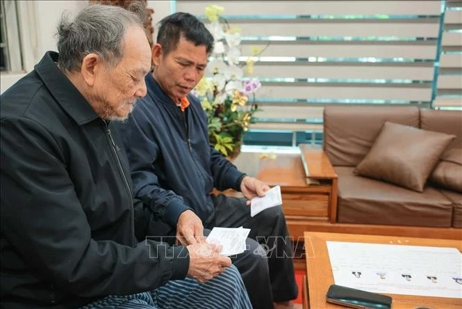 Nhân viên tổ bầu cử đưa thẻ cử tri đến hộ gia đình ông Nguyễn Trí Tuy, cụm dân cư số 3, thôn Hạ Mỗ, xã ô Diên (TP Hà Nội).