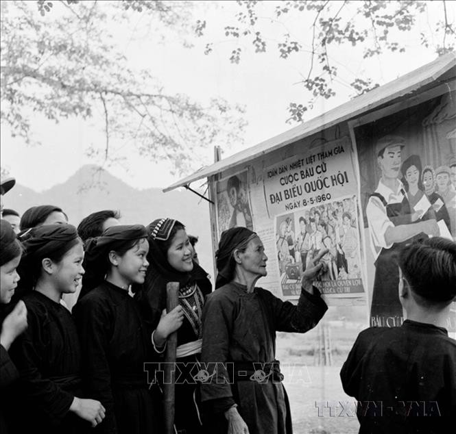 Đồng bào dân tộc Mán xem tranh cổ động bầu cử Quốc hội khóa II (1960).