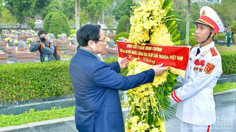 Thủ tướng Phạm Minh Chính chỉnh hoa trước khi thực hiện nghi lễ dâng hương, dâng hoa tưởng nhớ các Anh hùng liệt sĩ tại Nghĩa trang liệt sĩ quốc gia A1.