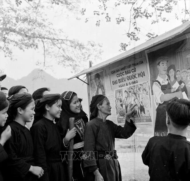 Đồng bào dân tộc Mán xem tranh cổ động bầu cử Quốc hội khóa II (1960).