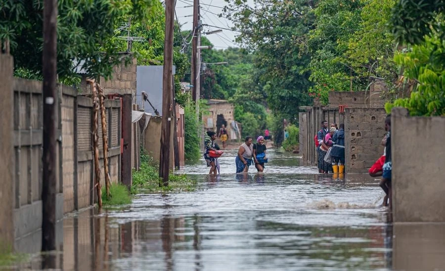 Người dân lội qua vùng nước lũ do mưa lớn tại thành phố Matola, tỉnh Maputo, Mozambique.