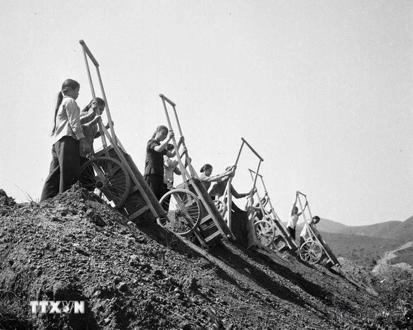 Hơn 70% số phụ nữ nông dân "Ba đảm đang" trên mặt trận sản xuất nông nghiệp với khí thế "tay cày, tay súng," vừa sản xuất vừa sẵn sàng chiến đấu. Trong ảnh: Tiểu đội 2 gồm toàn nữ thuộc Đại đội 551, Tổng đội 55 Thanh niên xung phong Hà Tĩnh mở đường mới cho xe ra tiền tuyến.