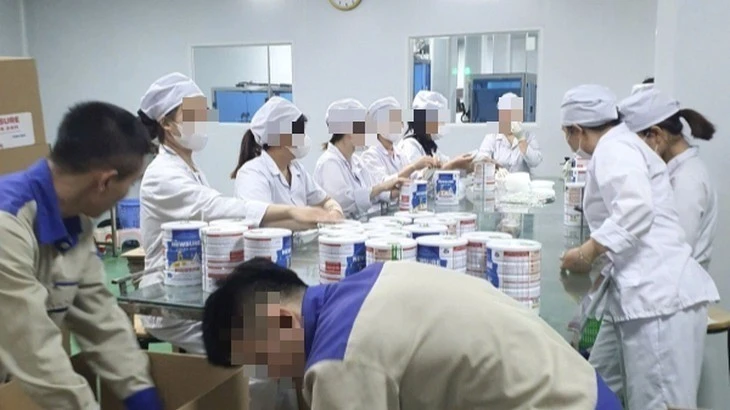Công nhân đóng hộp thành phẩm tại cơ sở sản xuất sữa bột giả quy mô lớn vừa bị Công an thành phố Hà Nội triệt phá.