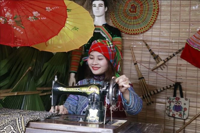 Du khách trải nghiệm may áo dân tộc Mông.