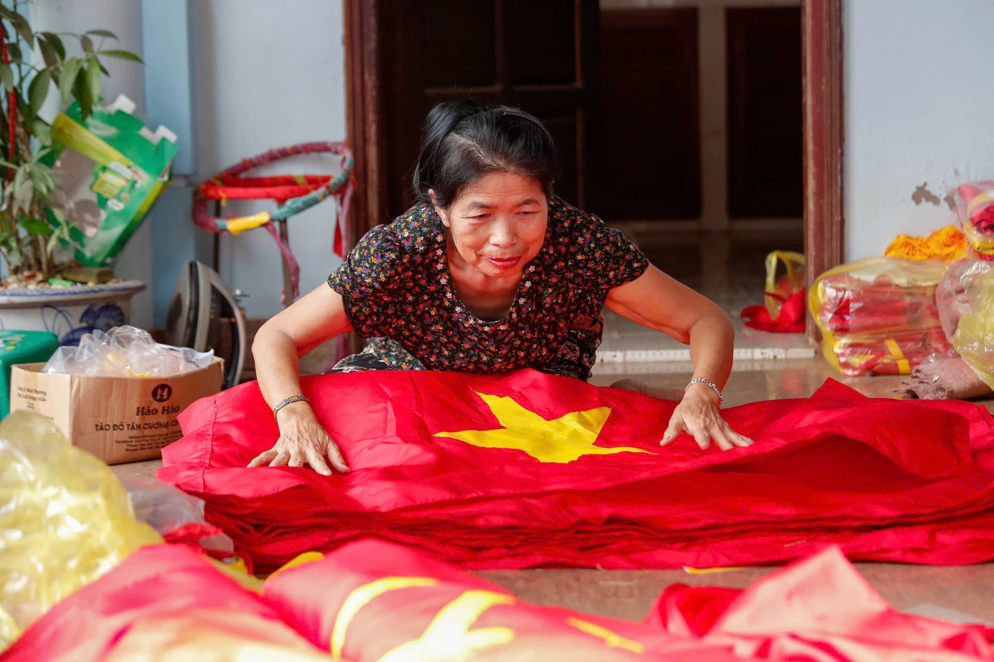 Gần đến ngày kỉ niệm giải phóng miền nam, thống nhất đất nước 30/4, các xưởng may trong làng trở nên nhộn nhịp, tất bật. Không khí làm việc khẩn trương bao trùm khắp nơi, sắc đỏ rực rỡ của cờ Tổ quốc hiện diện ở mọi góc xưởng.