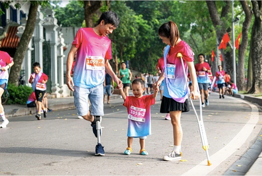 Tác phẩm "Hạnh phúc ngọt ngào" (Vũ Việt Hoa), chụp gia đình khuyết tật trong giải chạy vì sức khoẻ, giành huy chương Vàng cuộc thi ảnh, video "Việt Nam hạnh phúc". Ảnh: BTC