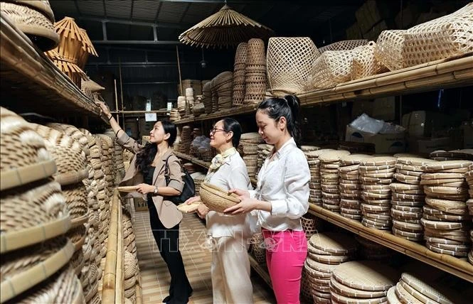 Khách chọn mua các sản phẩm mây tre đan truyền thống của Hợp tác xã Mây tre đan Thủy Tuyết.