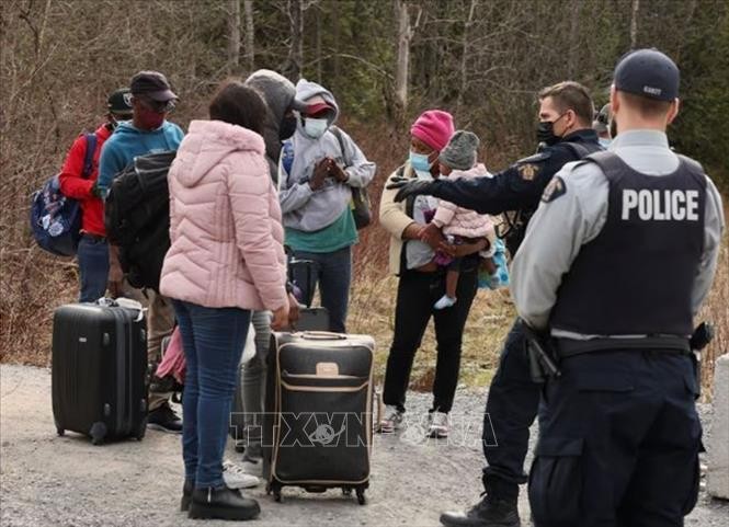 Cảnh sát chặn người di cư vượt biên từ Mỹ vào Canada tại trạm kiểm soát ở tỉnh Quebec (Canada). Cảnh sát chặn người di cư vượt biên từ Mỹ vào Canada tại trạm kiểm soát ở tỉnh Quebec (Canada).